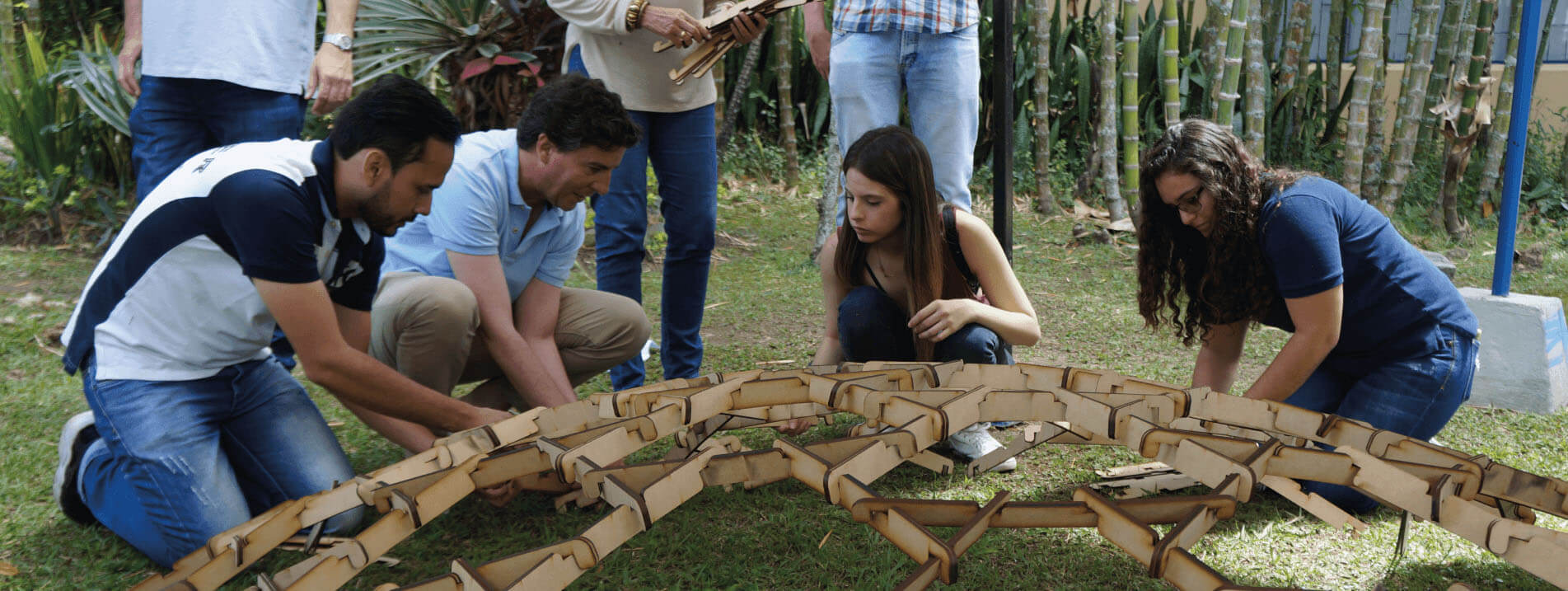 Estudiantes de la Escuela de Verano construyendo una estructura circular en madera